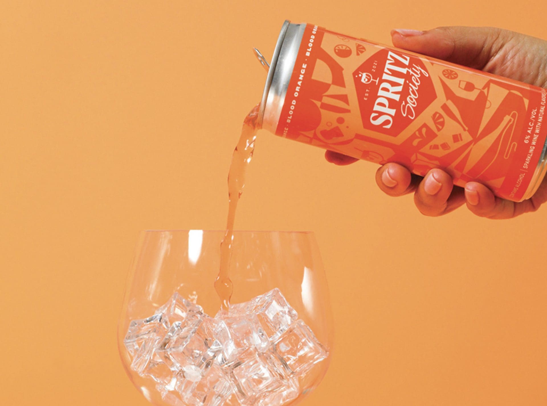 orange spritz society pouring into glass